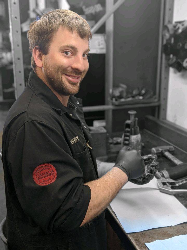 gerry. Red seal automotive technician happy. Canadian automotive expert working in garage.